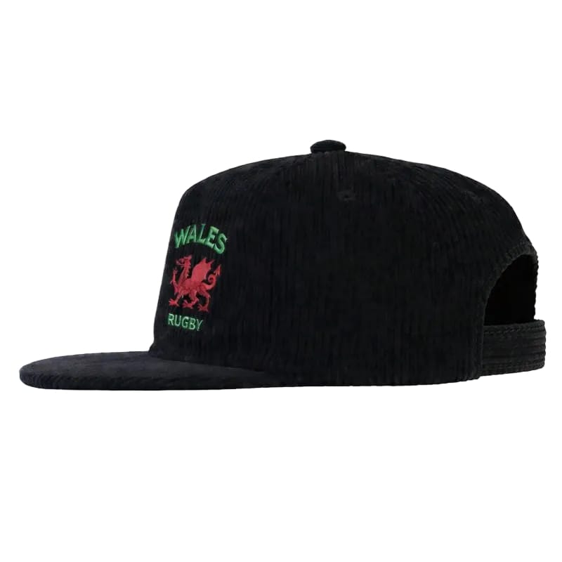 The EMB Weld Nations of Rugby Wales Corduroy Field Trip Cap features "WALES RUGBY" and a bold red dragon logo embroidered on black corduroy—a perfect pick for any Wales Rugby fan.