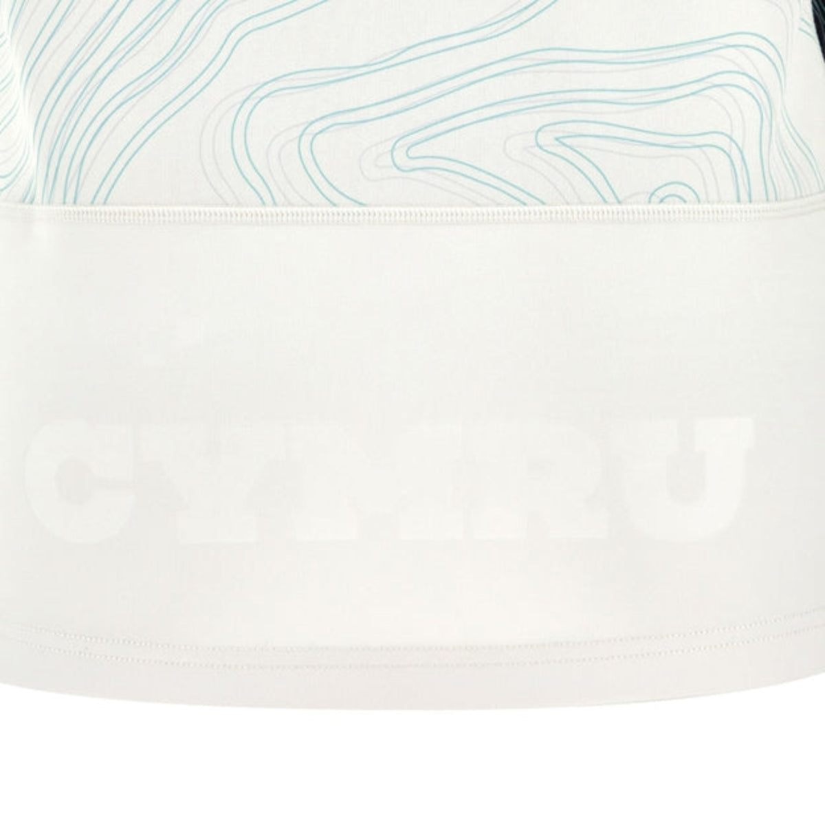 A close-up of white fabric with faint blue contours and "CYMRU" subtly printed near the bottom, showcasing an elegant detail from the Wales 25/26 Replica Away Jersey by Macron.