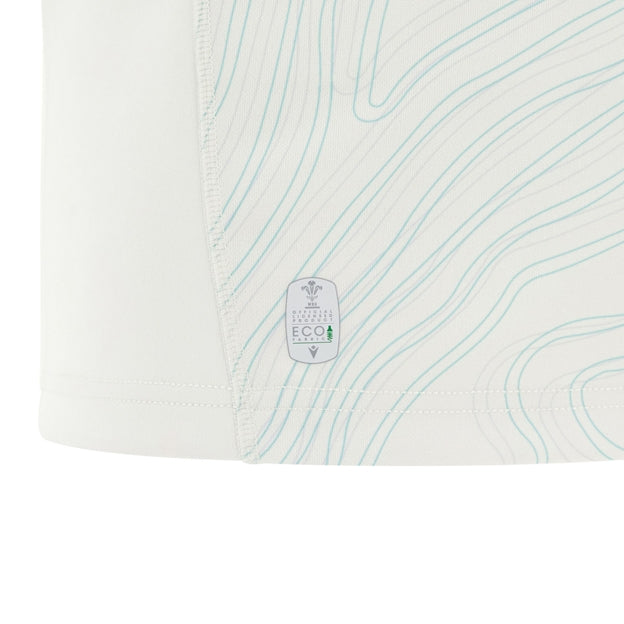 Close-up of a white fabric with light blue contour lines and an eco-friendly certification label near the hem—part of the Wales 25/26 Replica Away Jersey by Macron.