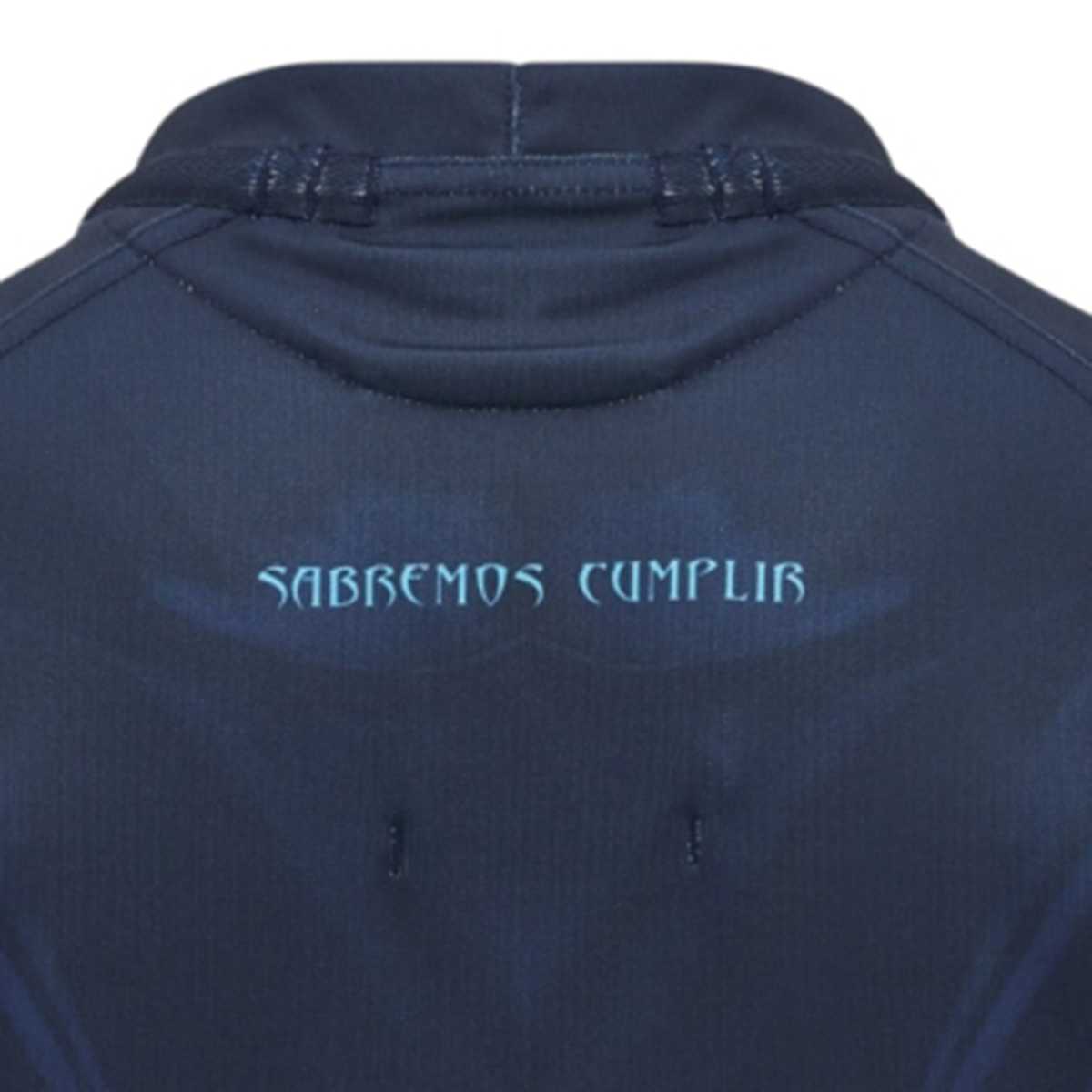 Close-up of the back of a Macron Uruguay URU 25/26 Replica Training Jersey in dark blue, featuring "SABREMOS CUMPLIR" in light blue text near the collar.