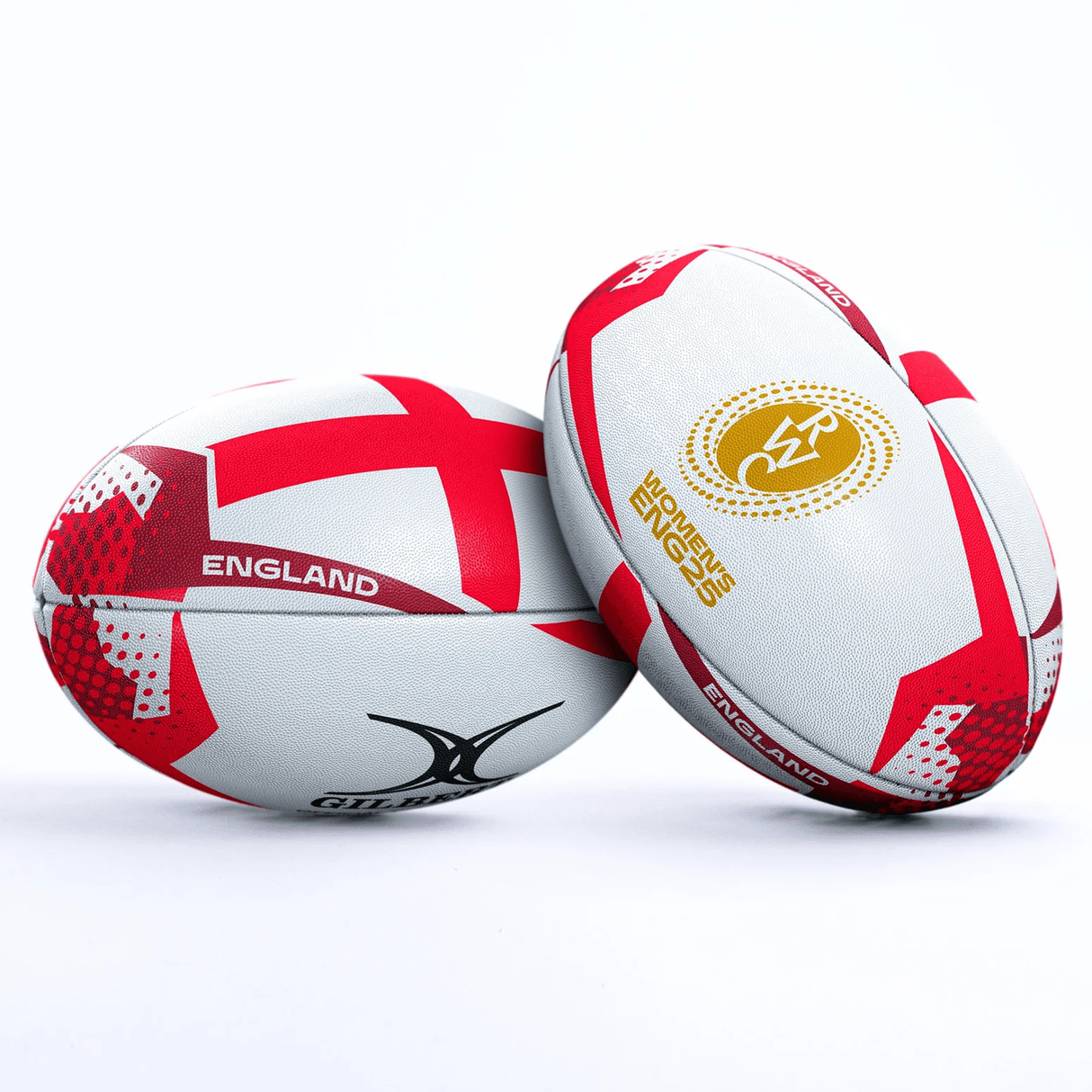 Two white Gilbert balls with red patterns and the "ENGLAND" label are upright, leaning against each other on a white background. They represent the Women's Rugby World Cup 25 England Team Ball by Gilbert.