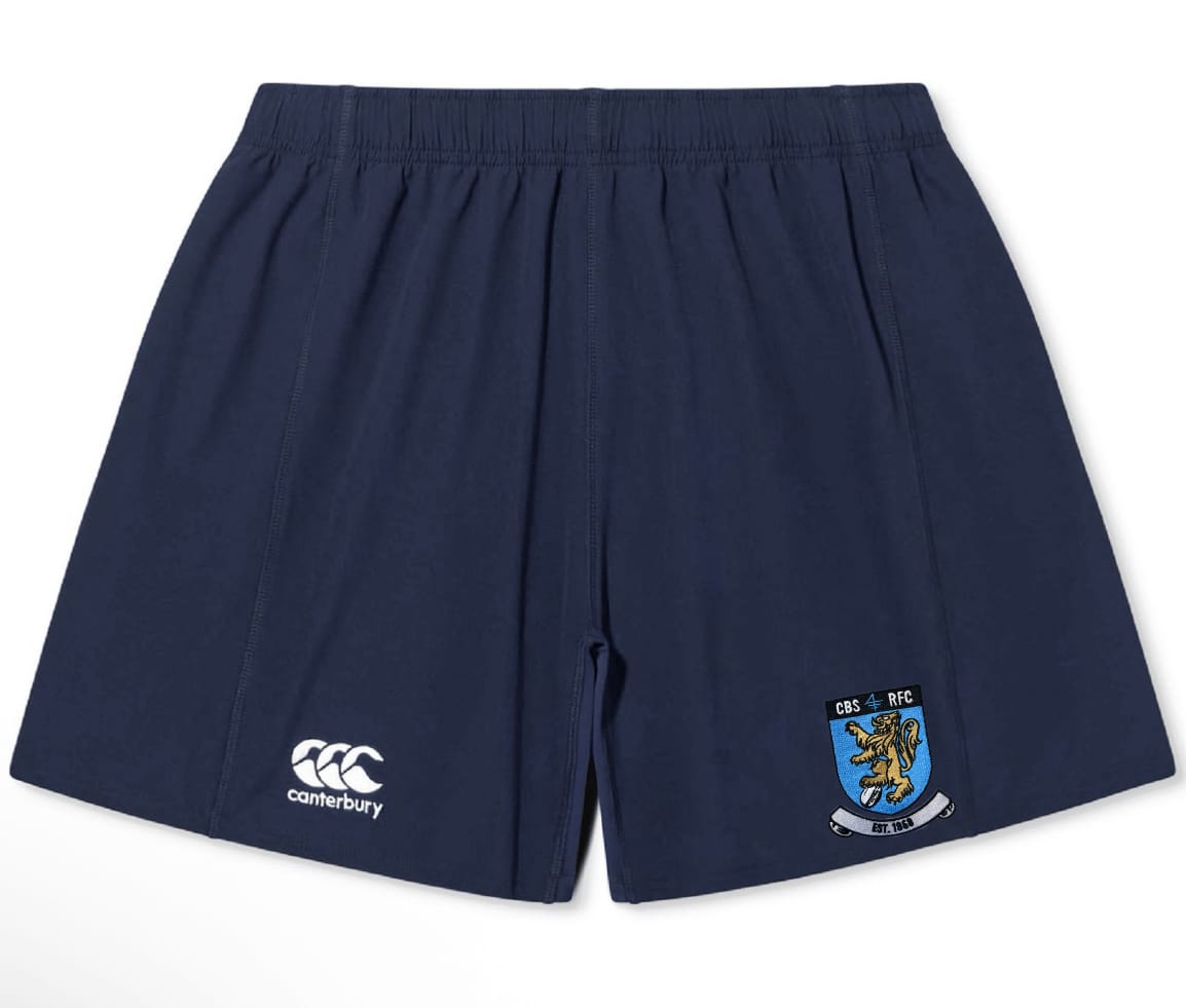 The Columbia Business Yokohama Short by EMB Canterbury features a navy blue design, elastic waistband, Canterbury logo on the left leg, and a shield-shaped lion crest on the right leg.