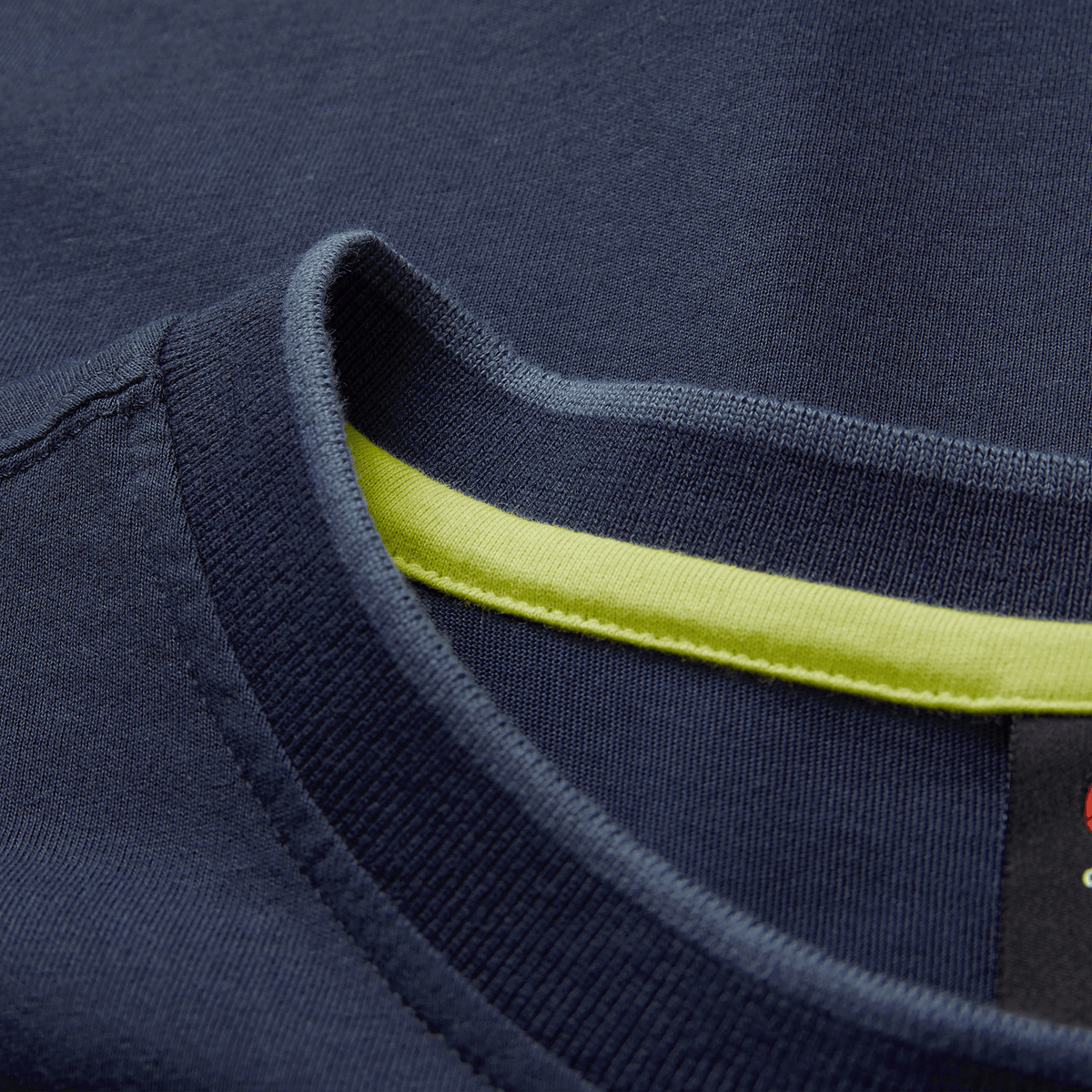 Close-up of the collar on the Ireland 26/27 Summer Tour Team Cotton T-Shirt by Canterbury in navy, showcasing a visible yellow inner trim and partial black label.