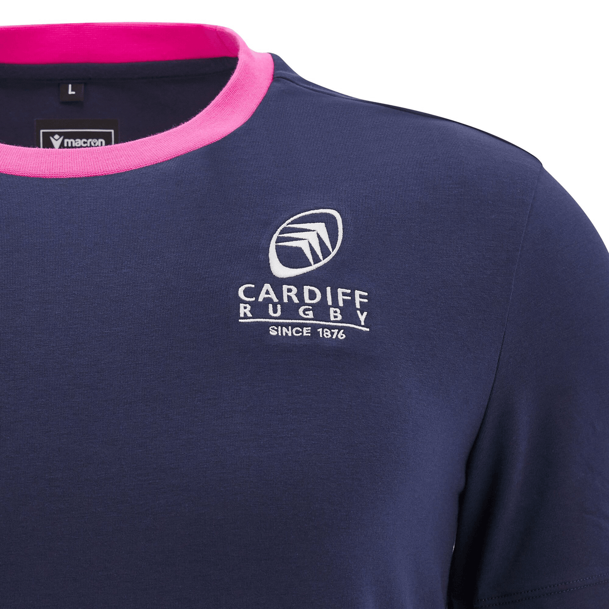 Close-up of the Cardiff 24/25 Anthem Travel Cotton T-Shirt by Macron in navy blue, featuring pink trim, the team's logo, and the text "SINCE 1876." Ideal for displaying your support on Anthem Travel adventures.