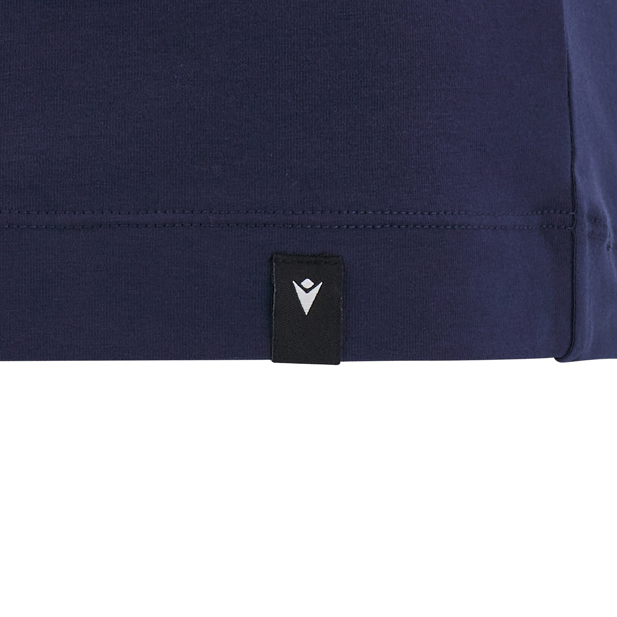 Close-up of a navy blue fabric from the Cardiff 24/25 Anthem Travel Cotton T-Shirt by Macron, featuring a small, black triangular logo with a white abstract symbol at the hem.