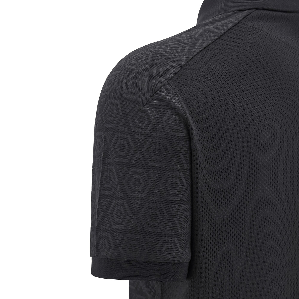 Close-up of a black Wales 24/25 Travel Polo by Macron, featuring a geometric pattern on the upper sleeve and shoulder.