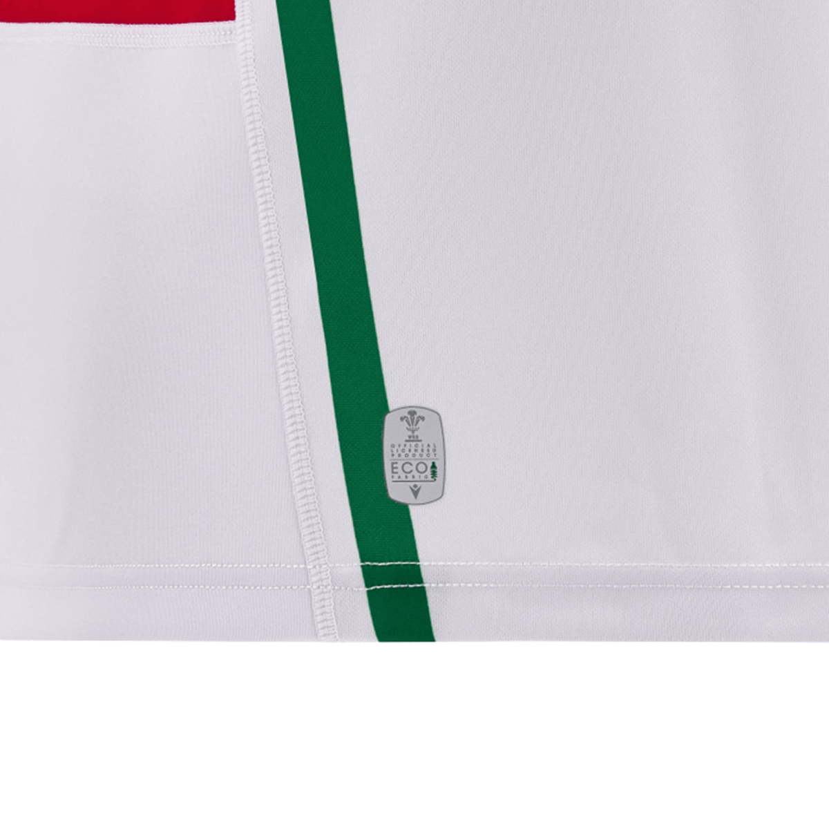 A close-up of a white fabric featuring vertical green and red stripes, reminiscent of the classic Wales 24/25 6 Nations Replica Away Jersey by Macron. There is an eco-friendly label near the bottom center, emphasizing sustainable craftsmanship.