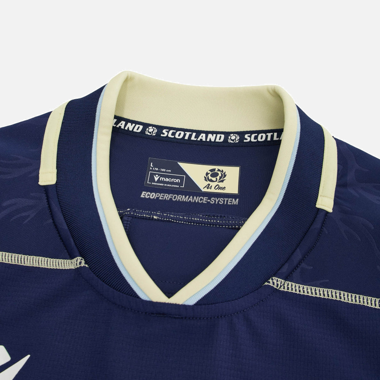 Close-up of the Scotland SRU 26/27 Authentic Matchday Home Jersey by Macron in dark blue, highlighting the collar with the Macron brand label, "SCOTLAND" text, and Ecoperformance-System tag—genuine matchday shirt details.