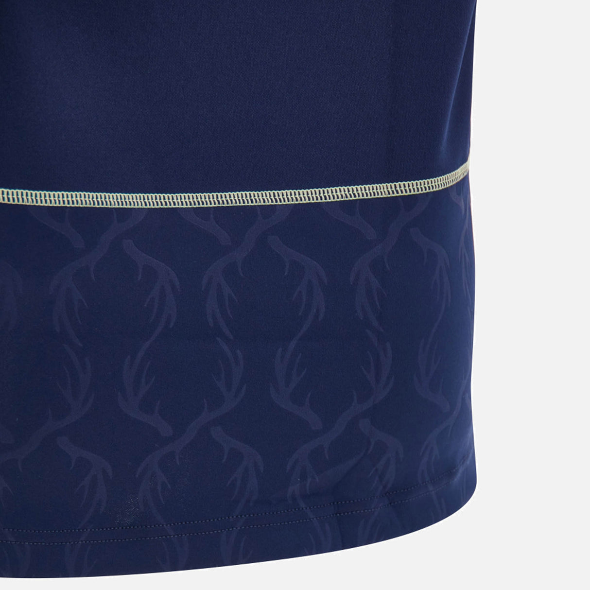 Close-up of a navy blue fabric from the Scotland SRU 26/27 Replica Home Jersey by Macron, featuring a subtle antler pattern and a horizontal beige stitched seam across the middle.