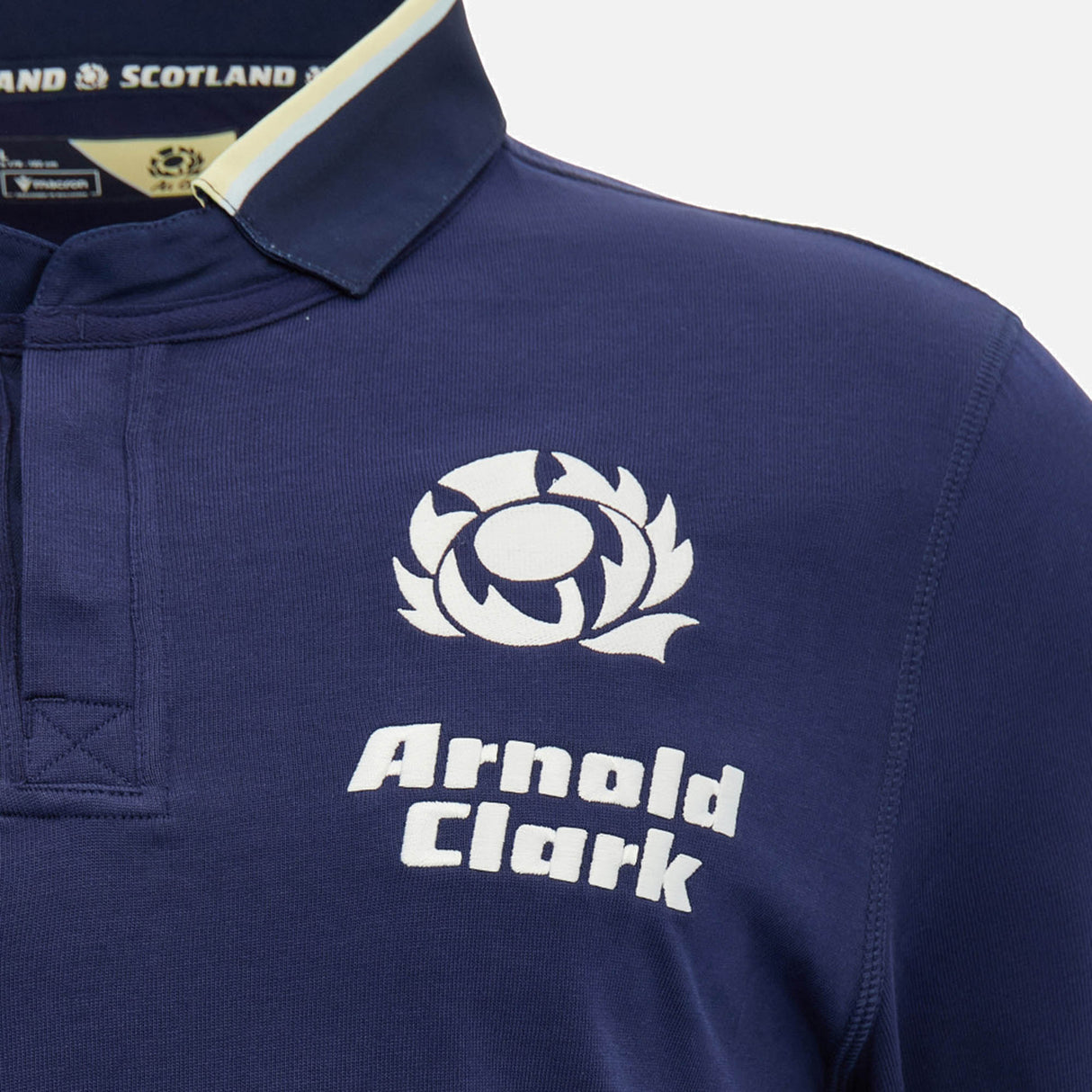 Close-up of the Scotland SRU 26/27 Cotton Replica Home Jersey by Macron in navy blue, featuring the Scottish Rugby logo and "Arnold Clark" sponsor text on the chest. This cotton replica from Macron showcases authentic home jersey details for passionate fans.