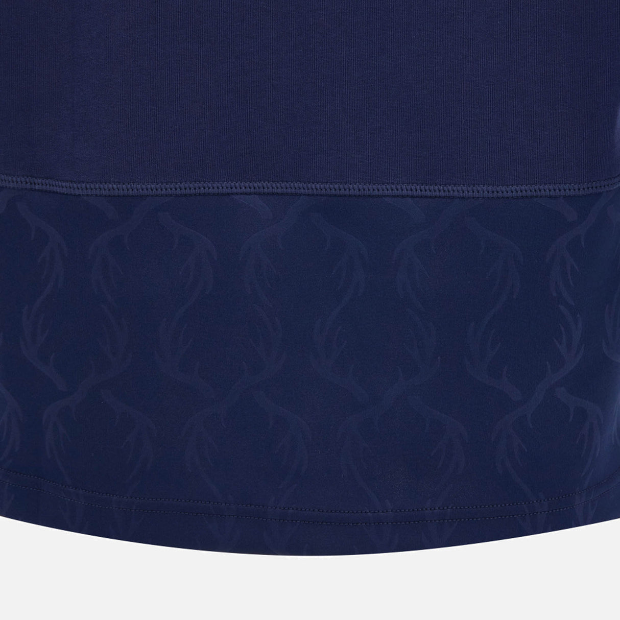 Close-up of the Scotland SRU 26/27 Cotton Replica Home Jersey by Macron in dark blue, highlighting the subtle deer antler pattern near the hem and visible stitching above this patterned section.