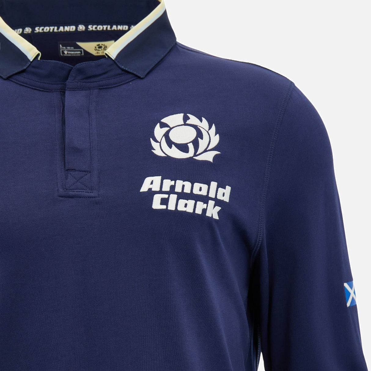 Show your support in comfort and style with the Scotland SRU 26/27 Cotton Replica Long Sleeve Home Jersey by Macron. This authentic navy blue home jersey features a thistle logo, "Arnold Clark" sponsor text, and a small Scottish flag on the right sleeve. Crafted from cotton for a classic look and feel, it’s the perfect long sleeve jersey for any Scotland rugby fan.