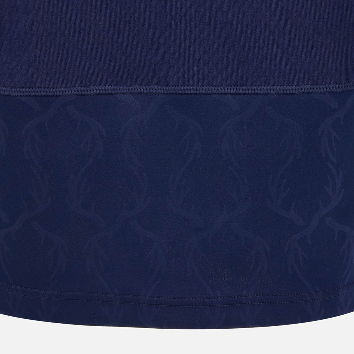 Crafted by Macron, the Scotland SRU 26/27 Cotton Replica Long Sleeve Home Jersey features dark blue fabric with a subtle, repeating antler pattern on the lower section and a visible seam separating two distinctive textures, inspired by the classic Scotland rugby jersey design.