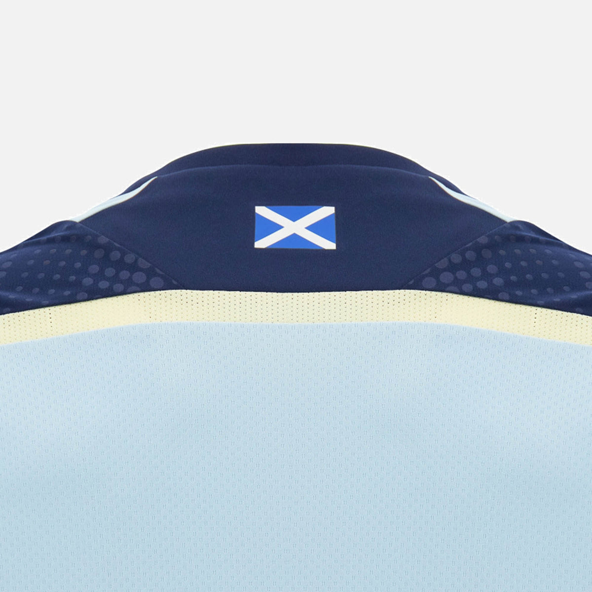 Back of the Scotland SRU 26/27 Player Training Shirt by Macron, featuring a small Scottish flag on the collar. The light blue jersey, made by Macron, showcases classic navy and yellow accents on a plain background—reflecting the iconic style of an official Scotland Rugby training shirt.