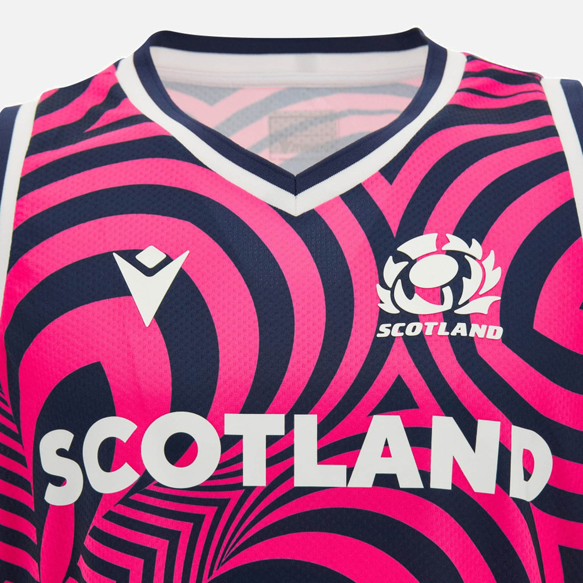 Close-up of the Scotland SRU 26/27 Basketball Singlet by Macron, a sleeveless top with bold pink and navy patterns. It features "SCOTLAND" text and a thistle rugby emblem on the chest. This Macron singlet combines eye-catching style with athletic performance for Scottish Rugby training.