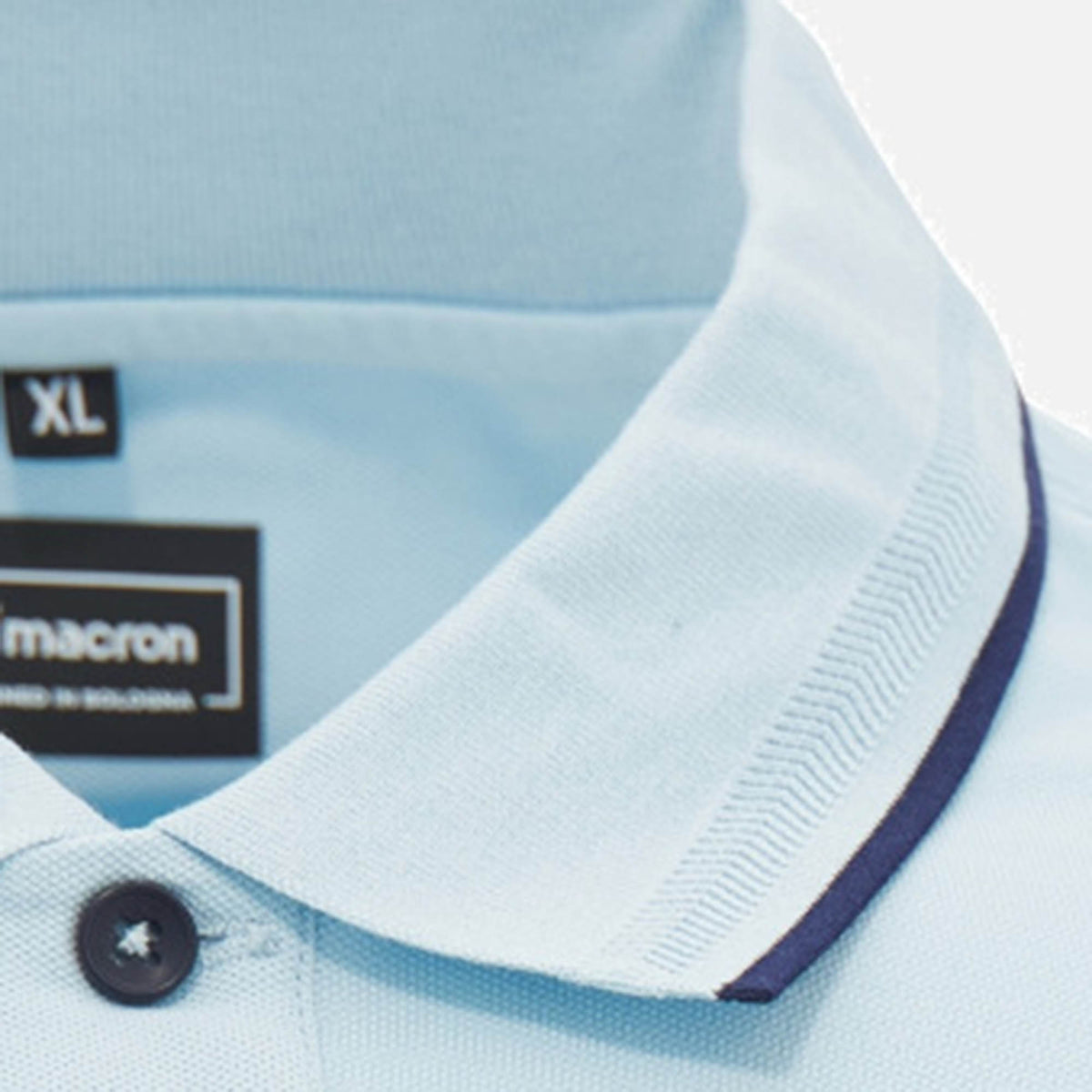 Close-up of the Scotland SRU 26/27 Travel Polo by Macron in light blue, featuring a collared design with a dark blue trim along the edge and a black size XL label.