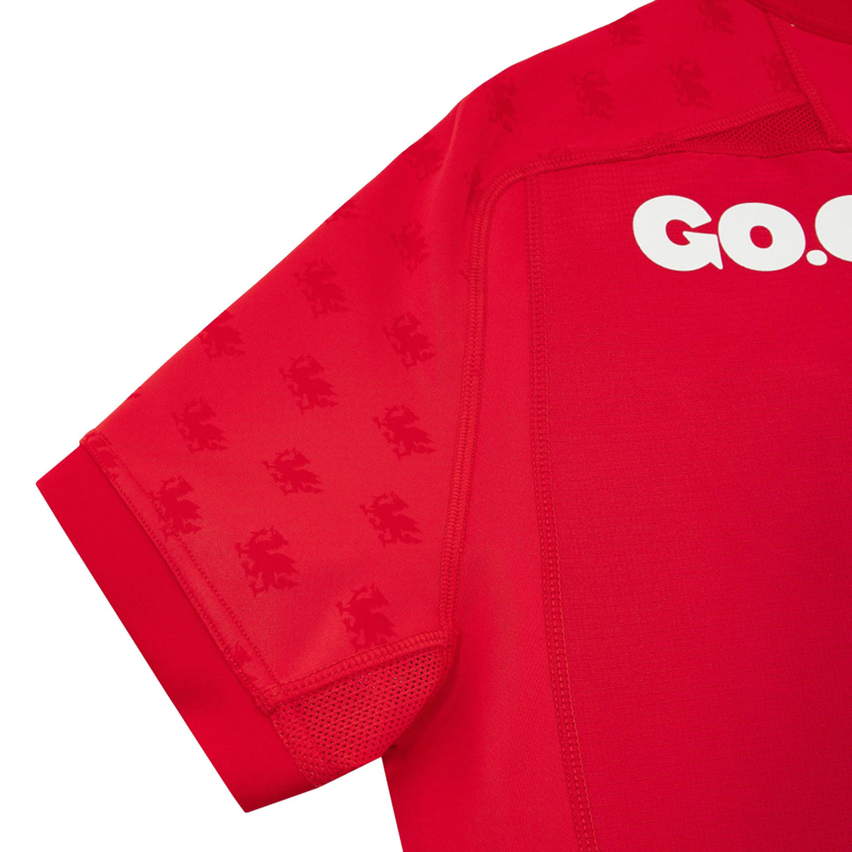 Close-up of the Wales WRU 26/27 Authentic Matchday Home Jersey by Macron—a red, short-sleeved jersey featuring subtle lion motifs on the sleeves and shoulders, and bold “GO.” lettering in white across the chest—an official matchday design crafted for dedicated fans.