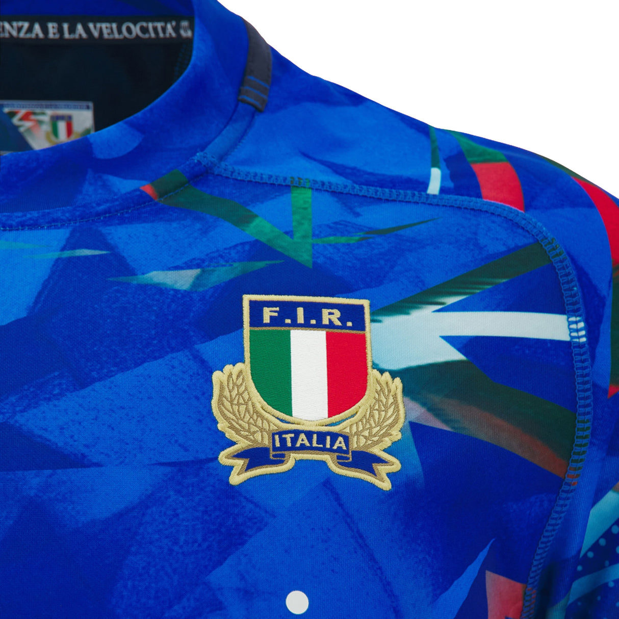 Close-up of the Italy 26/27 Home Replica Jersey by Macron, a blue rugby jersey featuring the Italian Rugby Federation (F.I.R.) crest and Italy’s flag colors on the chest.