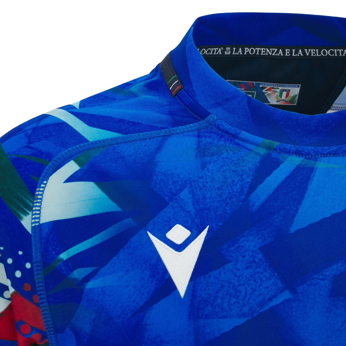 Close-up of the Italy 26/27 Home Replica Jersey by Macron in blue, showcasing abstract patterns, a white Macron logo, and a collar tag with Italian text along with the partially visible Italian rugby badge—a striking jersey designed by Macron for passionate fans.