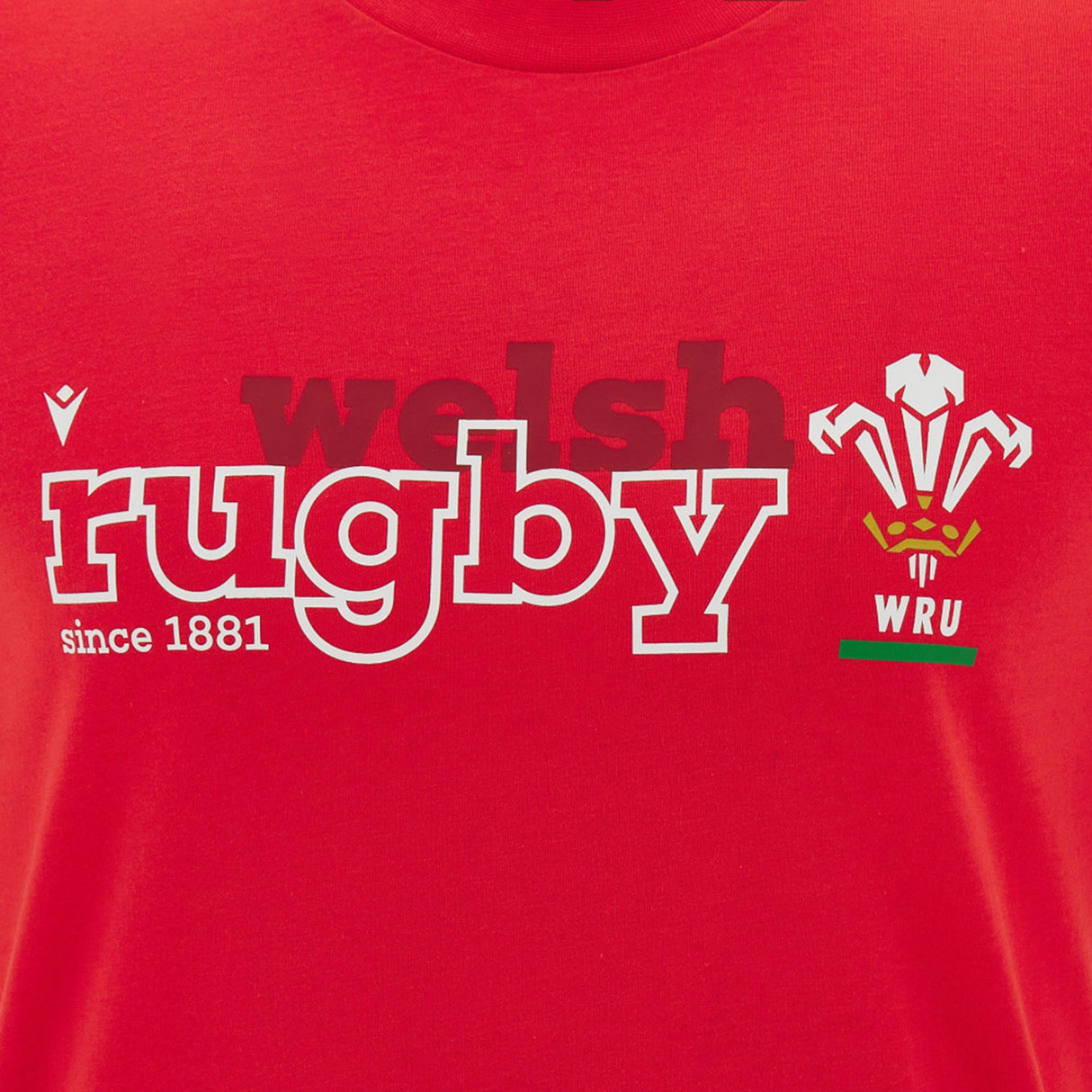 The Wales WRU 26/27 “Welsh Rugby” Fan Cotton T-Shirt by Macron is a red shirt featuring the “welsh rugby since 1881” text and the iconic Welsh Rugby Union (WRU) logo with three feathers above the “WRU” letters. This official T-shirt is crafted by Macron for dedicated rugby fans.