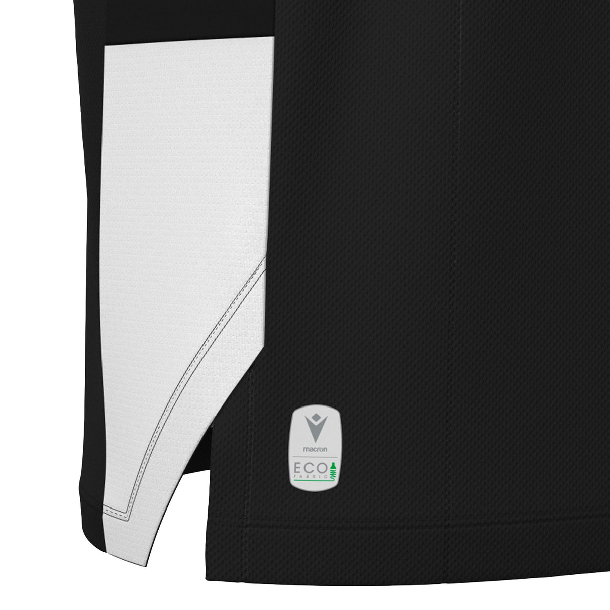 Close-up of the hem of the black and white Wales WRU 26/27 Travel Basketball Singlet by Macron, showing a Macron ECO logo tag with a tree graphic on the lower edge.