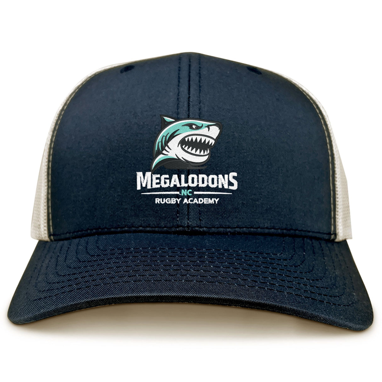 The EMB S&S Activewear NC Rugby Academy - Megalodons Retro Trucker Cap features a navy front, white mesh back, embroidered shark logo with "Megalodons Inc Rugby Academy," and an adjustable snapback for comfort.