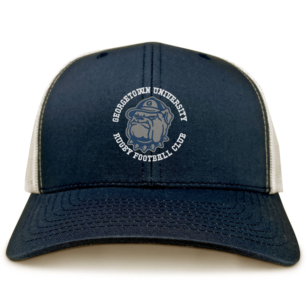 The EMB S&S Activewear Georgetown University RFC Retro Trucker Cap features a blue and white design, a front embroidered Rugby Football Club bulldog logo, and a classic snapback closure for an adjustable fit.