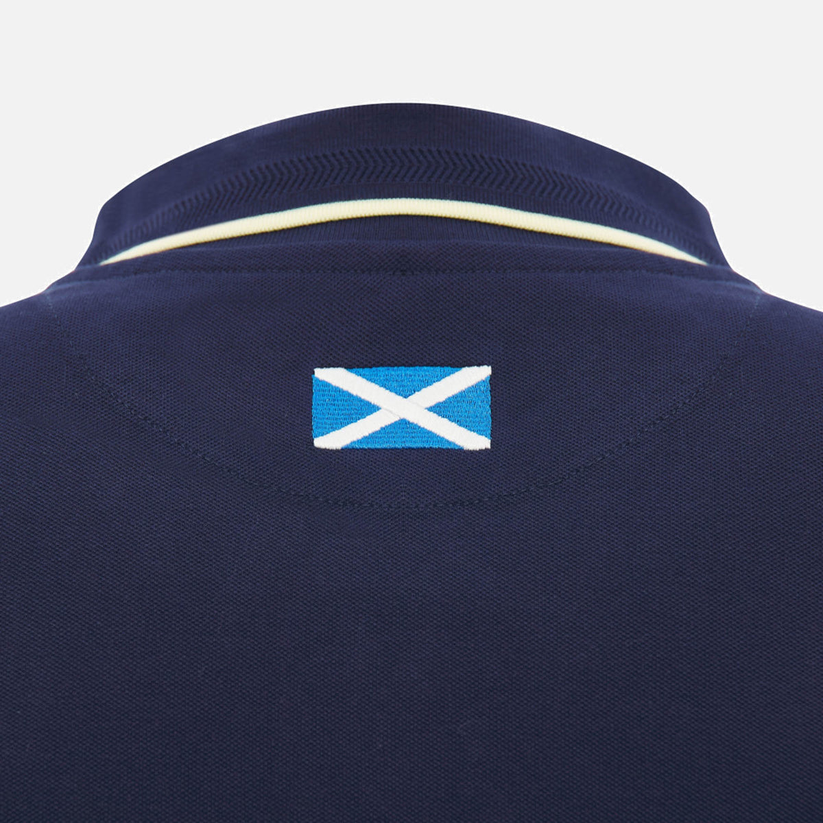 Close-up of the back of the Scotland SRU 26/27 Travel Polo by Macron in navy, featuring a small Scottish flag patch below the collar.