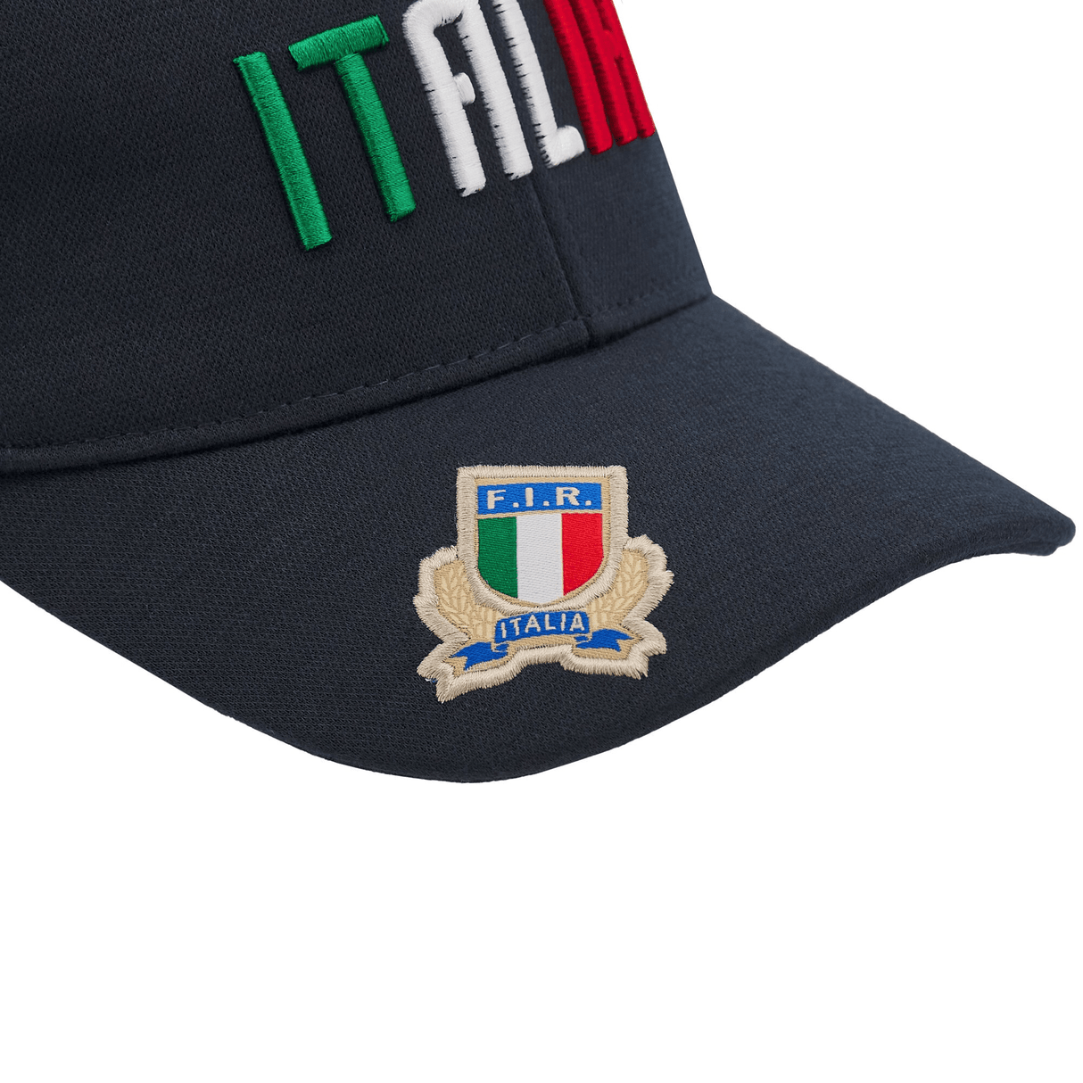 The Italy Curved Visor Cap 24/25 by Macron showcases a navy blue design with "ITALIA" embroidered in green, white, and red. The F.I.R. Italia logo adorns the brim, highlighting the distinctive style of Macron's latest collection.