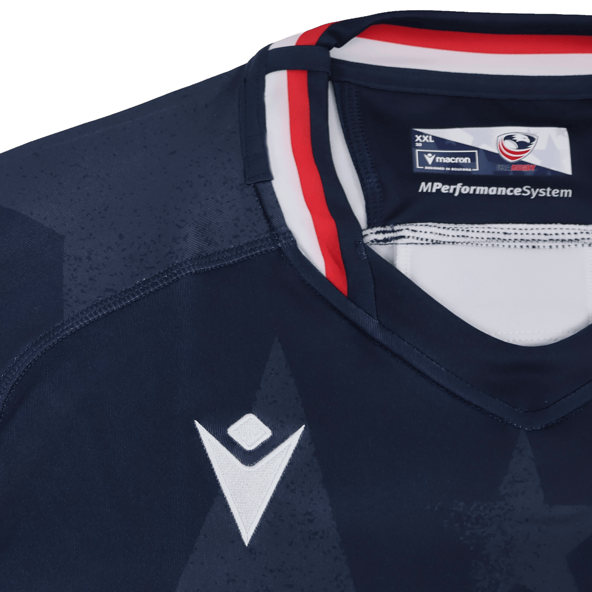 Close-up of the Women's USA Rugby 24/25 Home Body Fit Jersey by Macron in navy blue, with a white Macron logo, red and white collar trim, and "MPerformanceSystem" on the inner neck label.