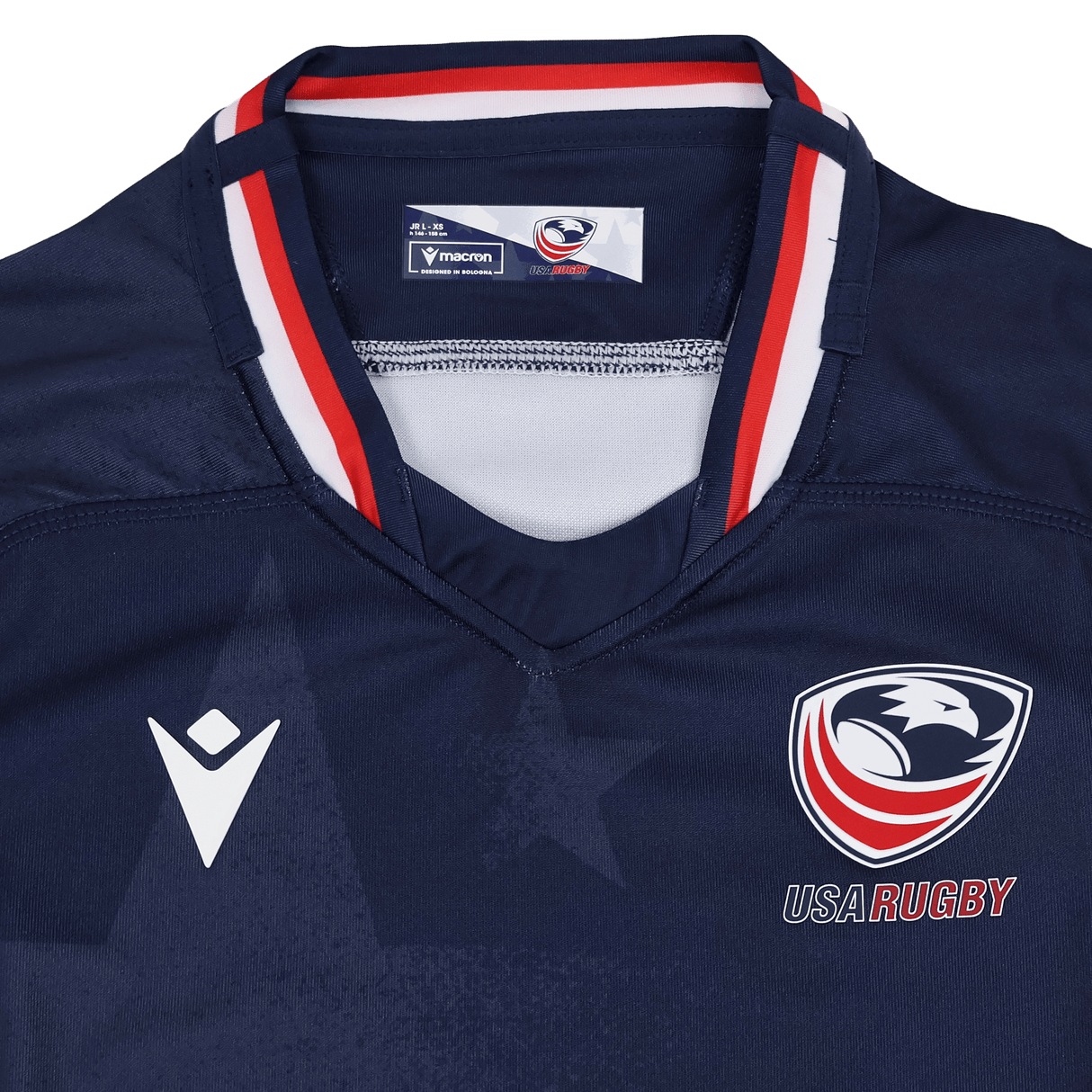The Youth USA Rugby 24/25 Home Jersey by Macron is a navy blue jersey featuring the USA Rugby eagle logo, the Macron logo, and red, white, and blue collar accents.