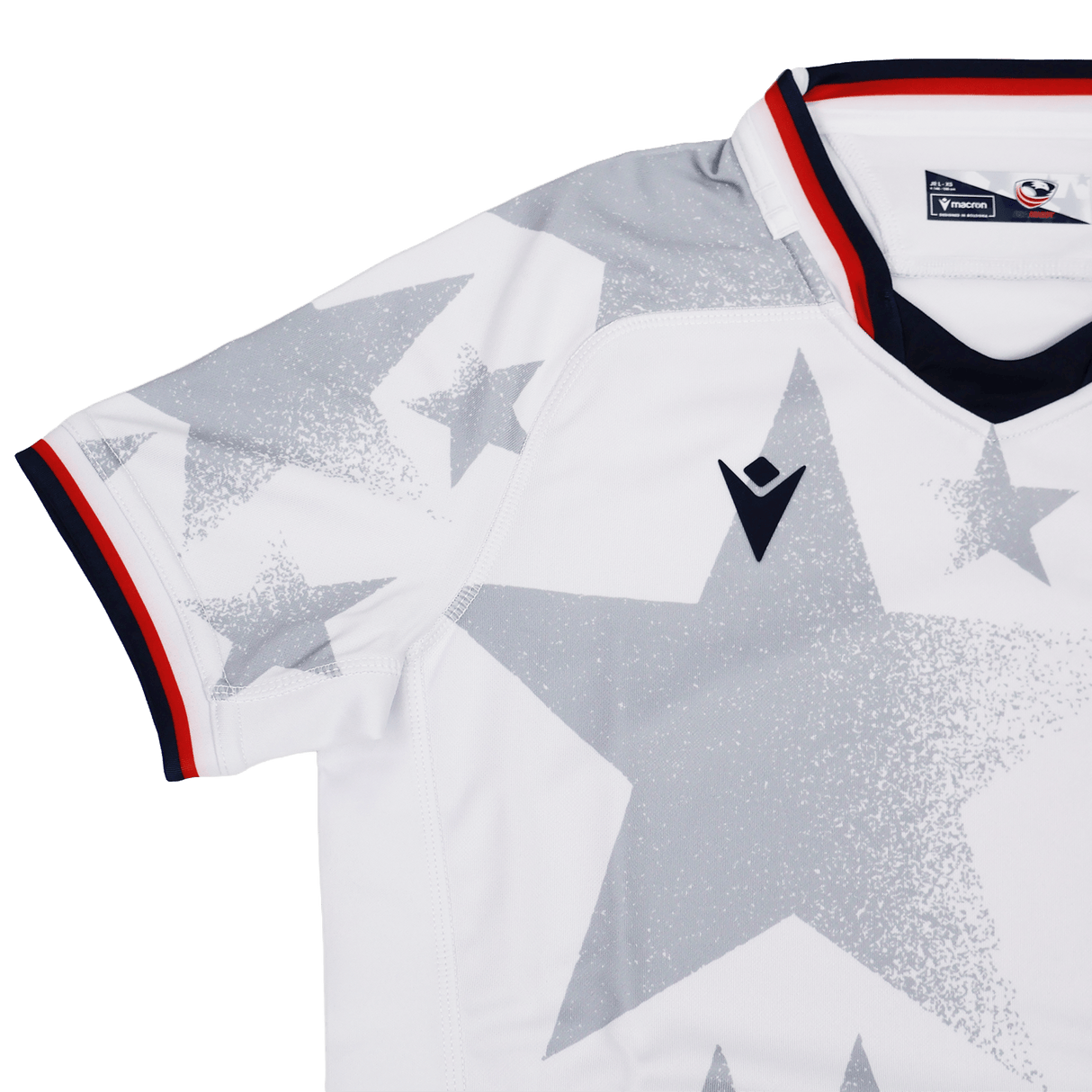 The Youth USA Rugby 24/25 Away Jersey by Macron features a white design with large gray stars, black and red collar trim, and a black Macron logo on the chest.