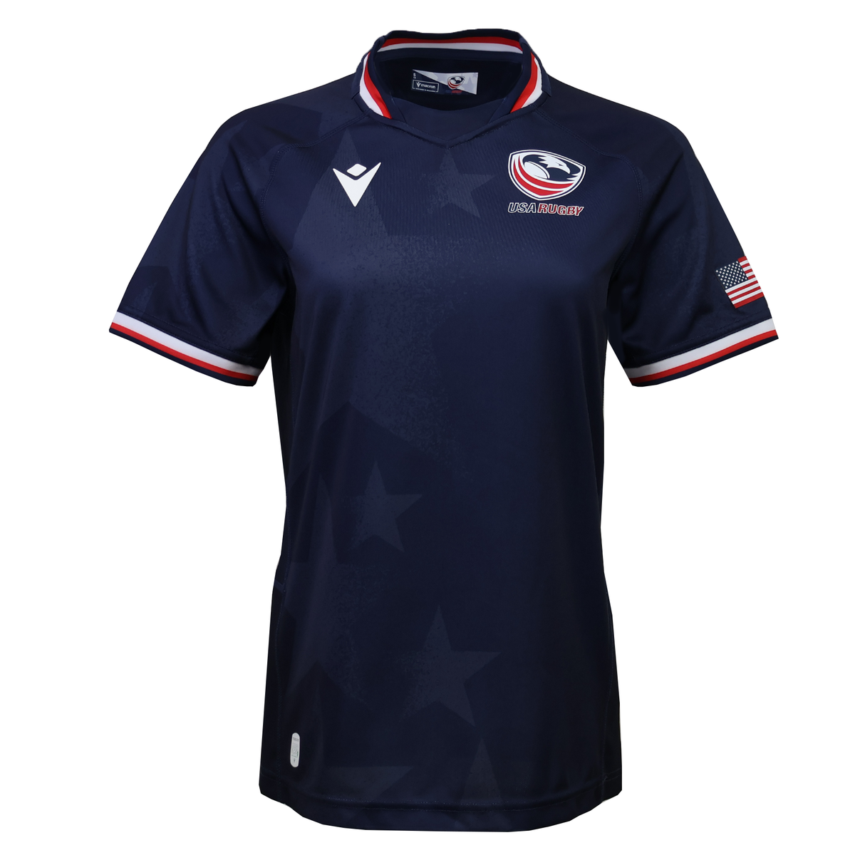 The Women's USA Rugby 25/26 Replica Home Jersey by Macron features a navy blue design, USA Rugby logo, white Macron logo, American flag patch on the sleeve, red-white-blue trim on collar and sleeves, and a subtle star pattern.