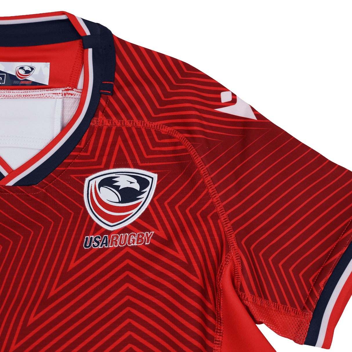 Close-up of the Youth USA Rugby Training Jersey by Macron, a red jersey with white and navy geometric patterns and the USA Rugby logo—ideal for fans or as training wear. Brand: Macron.