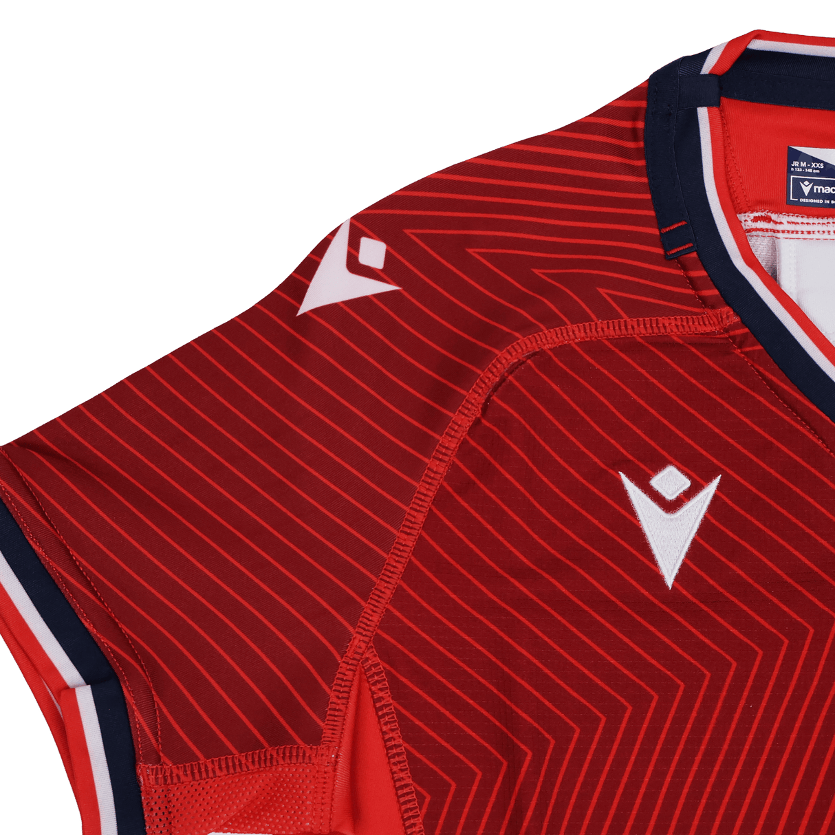 Close-up of the Youth USA Rugby Training Jersey by Macron, showcasing a red sports design with white geometric patterns, white logo, and navy blue and white trim on the collar and sleeves.
