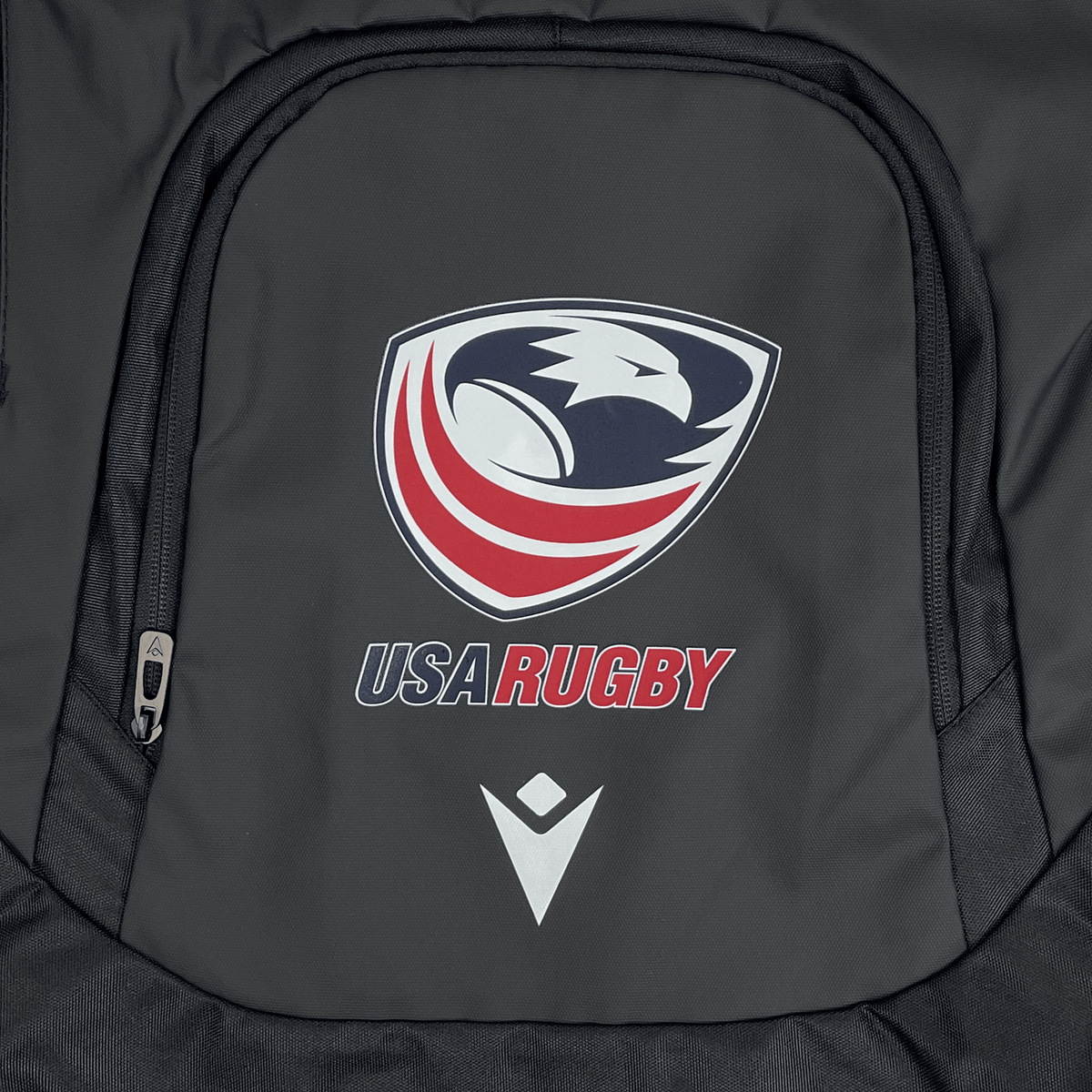 The USA Rugby 25 Gymsack by Macron is a black waterproof bag featuring a stylized eagle, red stripes, "USA Rugby" text, and the Macron logo below.
