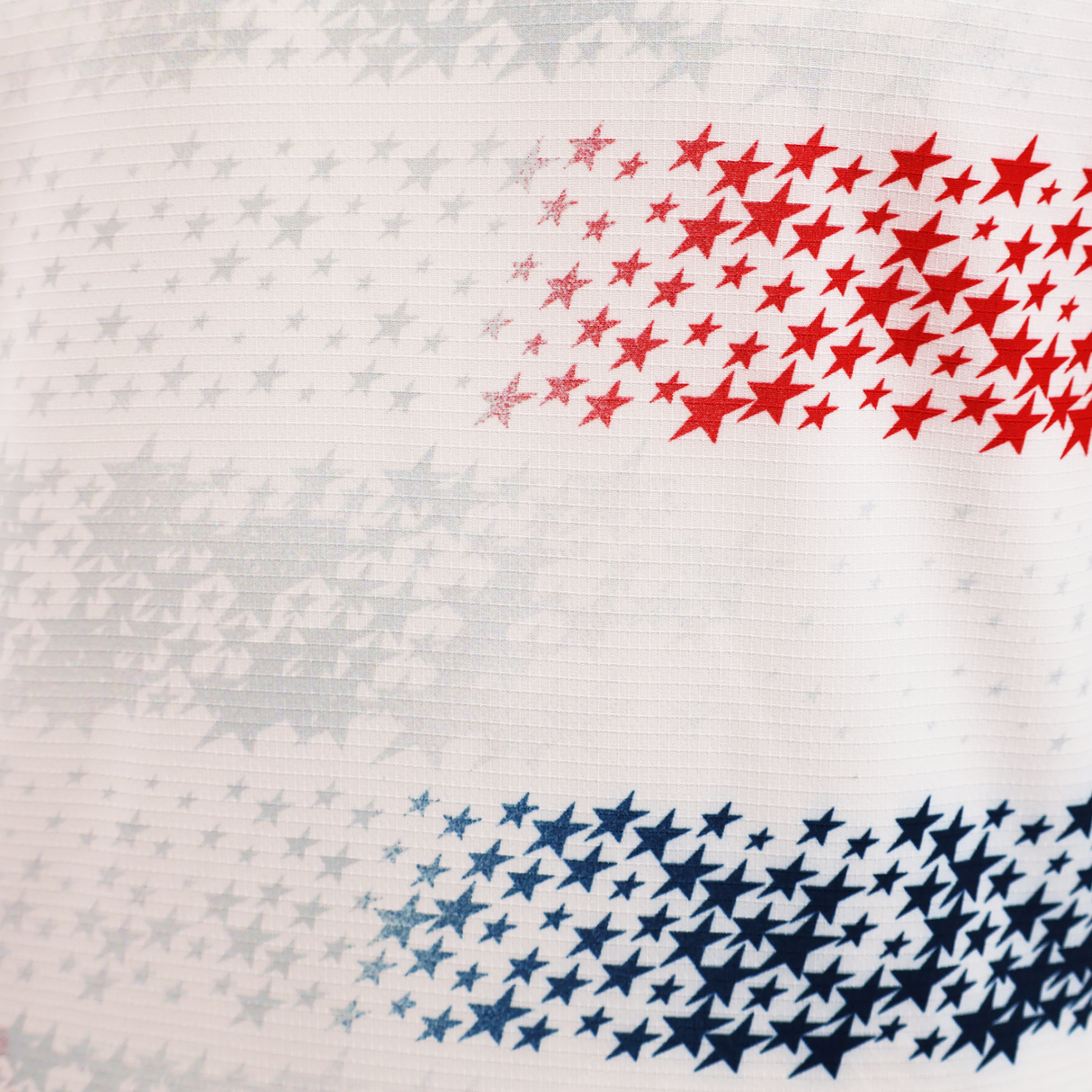 Close-up of the USA Rugby 25/26 Home Body Fit Match Jersey by Macron, featuring a white design with small red, blue, and light gray stars in horizontal clusters.