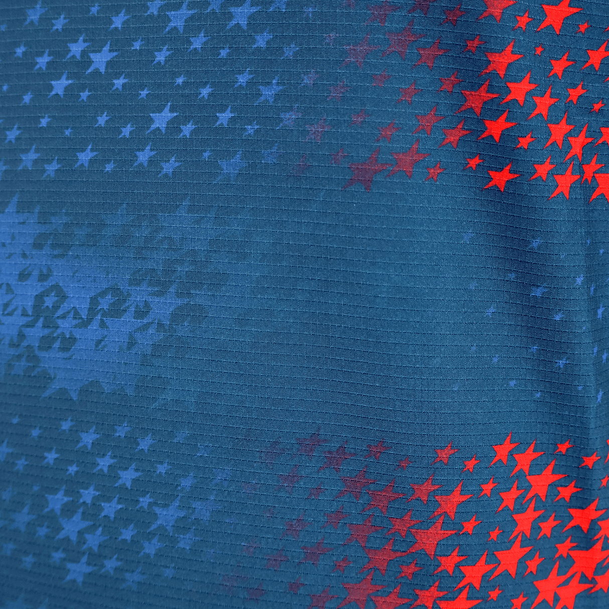 The USA Rugby 25/26 Away Body Fit Match Jersey by Macron features blue fabric with red and blue stars fading from right to left—ideal for high-performance, inspired by classic USA Rugby designs.