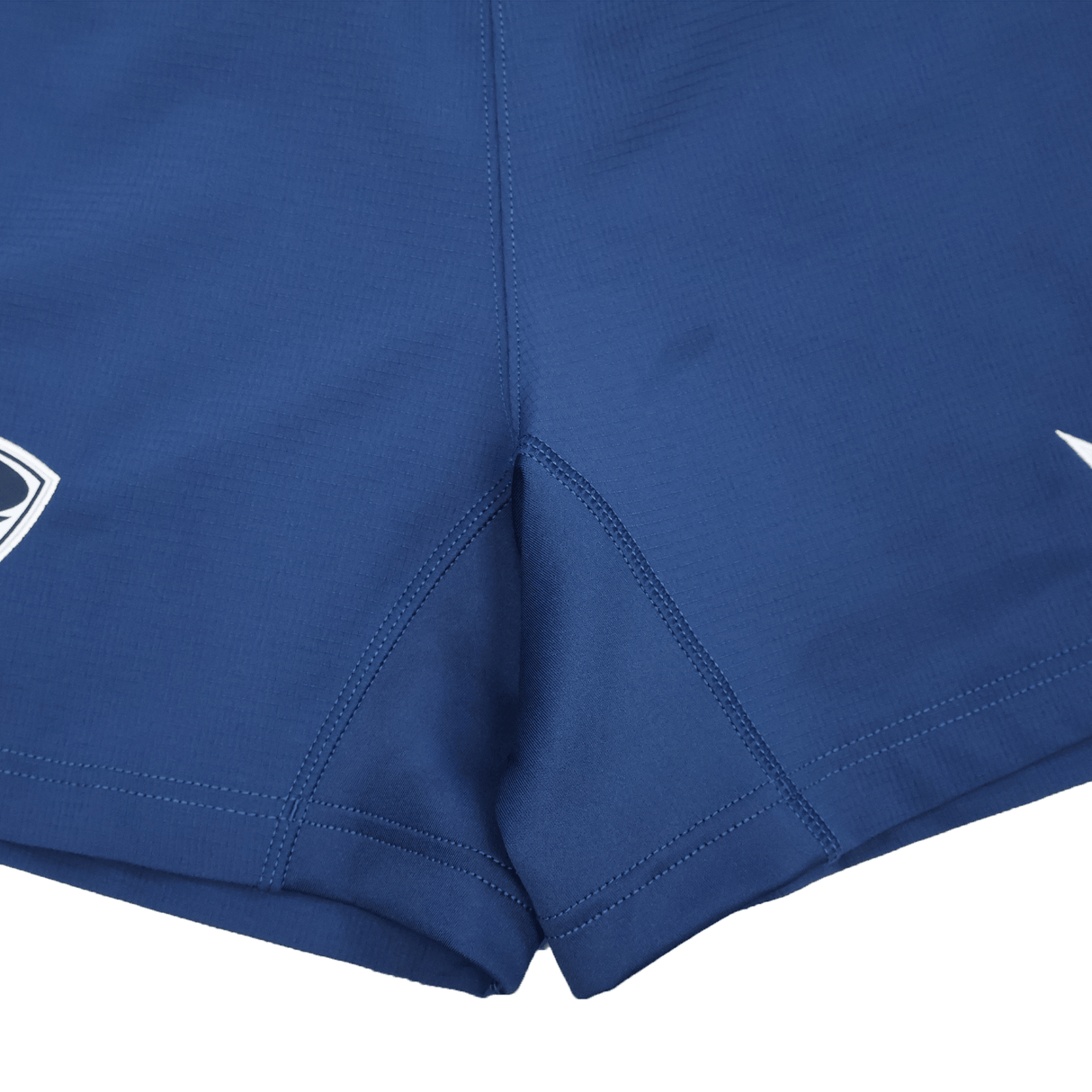 Close-up of blue USA Rugby 25/26 Away Shorts by Macron, featuring stitched seams and small white Macron logos on each leg.