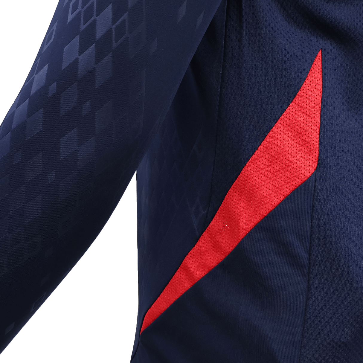 Close-up of the USA Rugby 25/26 LS Training Poly Shirt by Macron, featuring navy blue polyester, a red diagonal stripe, and subtle geometric patterns on the sleeve.