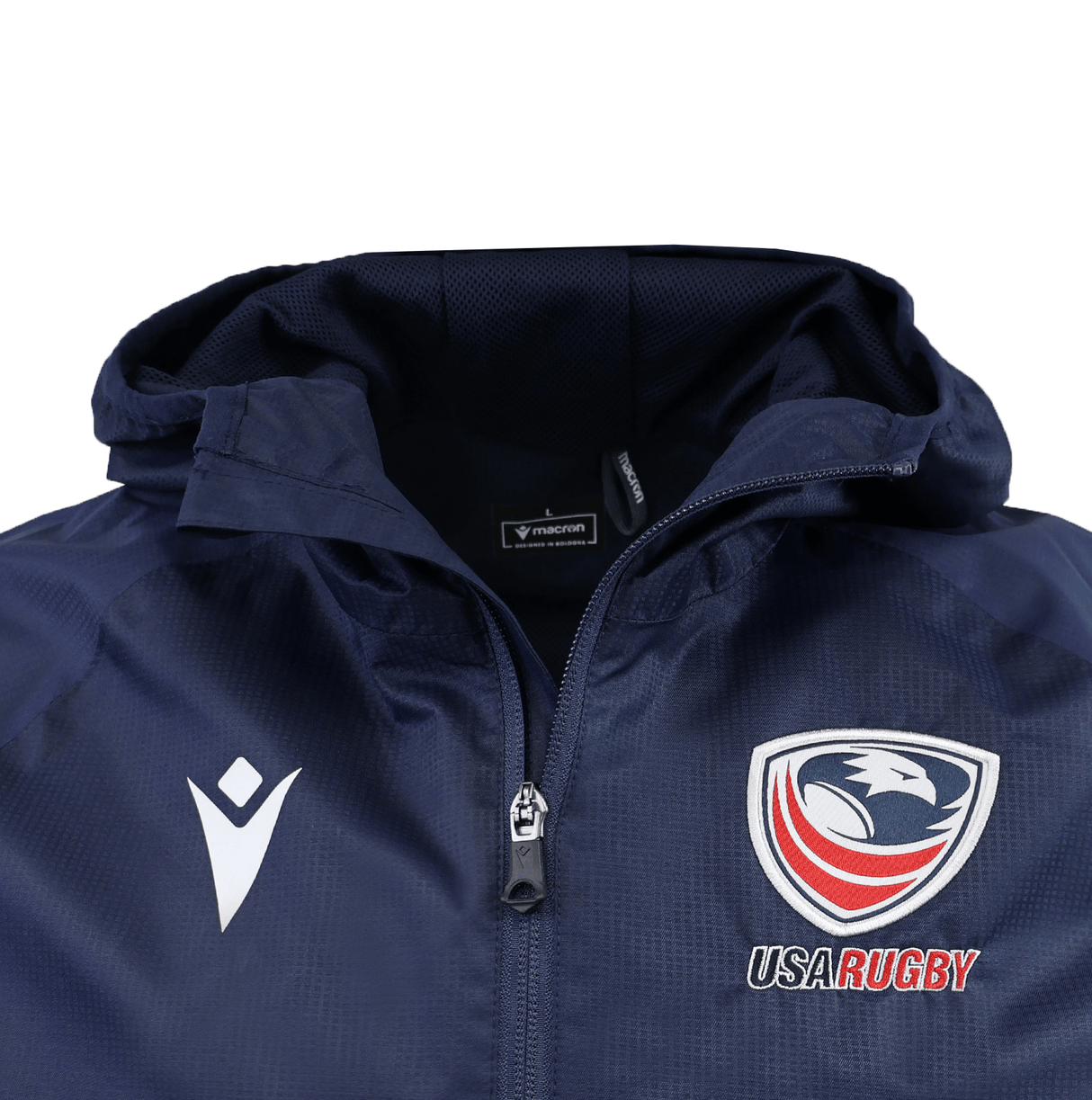 The USA Rugby 25/26 Rain Jacket by Macron is a navy blue waterproof zip-up with a hood, featuring the Macron logo on the left chest and the USA Rugby eagle logo with text on the right chest.