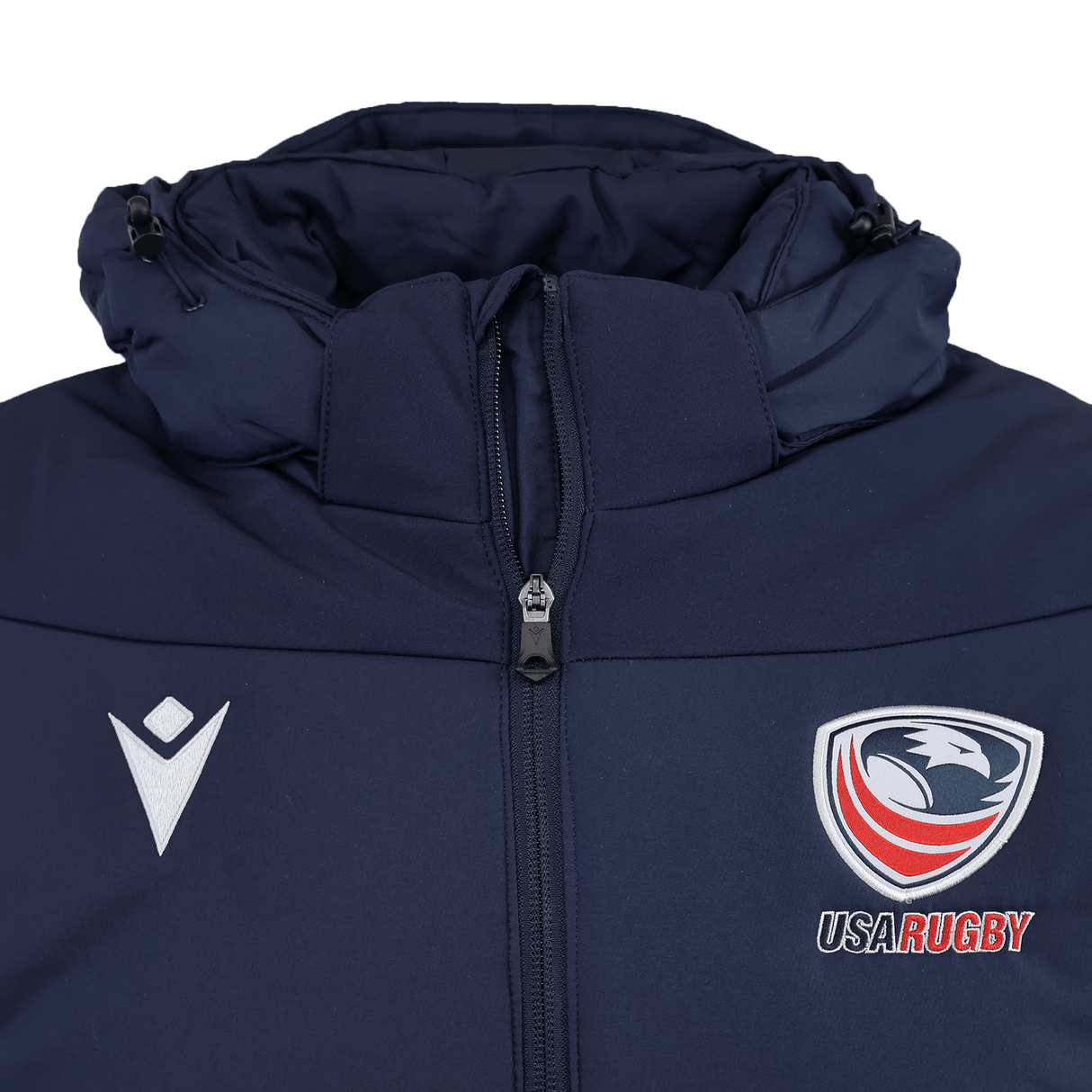 The USA Rugby 25/26 Padded Jacket by Macron is a navy blue zip-up with padding, featuring the USA Rugby eagle logo on the right chest and a white Macron logo on the left.