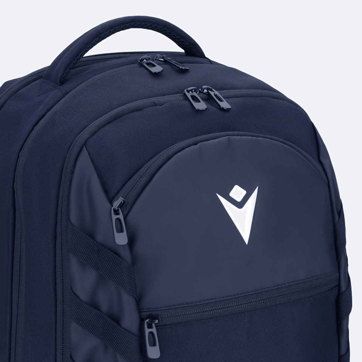 The USA Rugby 25/26 Athleisure Backpack by Macron is a spacious navy blue backpack with multiple zippered compartments and a white geometric logo on the front pocket, ideal for athleisure or daily use.