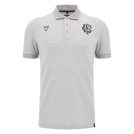 The Barbarians 25/26 Player Travel Polo by Macron is a light grey short-sleeve polo with a three-button placket, black embroidered chest logos, and a classic collar.