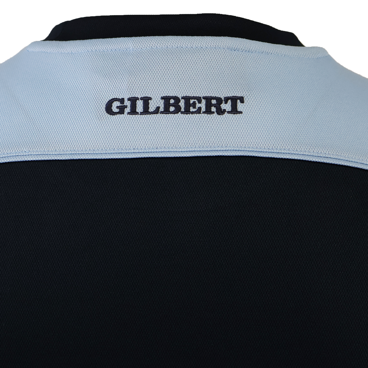 Close-up of the Gilbert Photon Training Tee’s back, showing "GILBERT" embroidered in black on a light blue panel above black, designed ergonomically with moisture-wicking fabric for comfort.