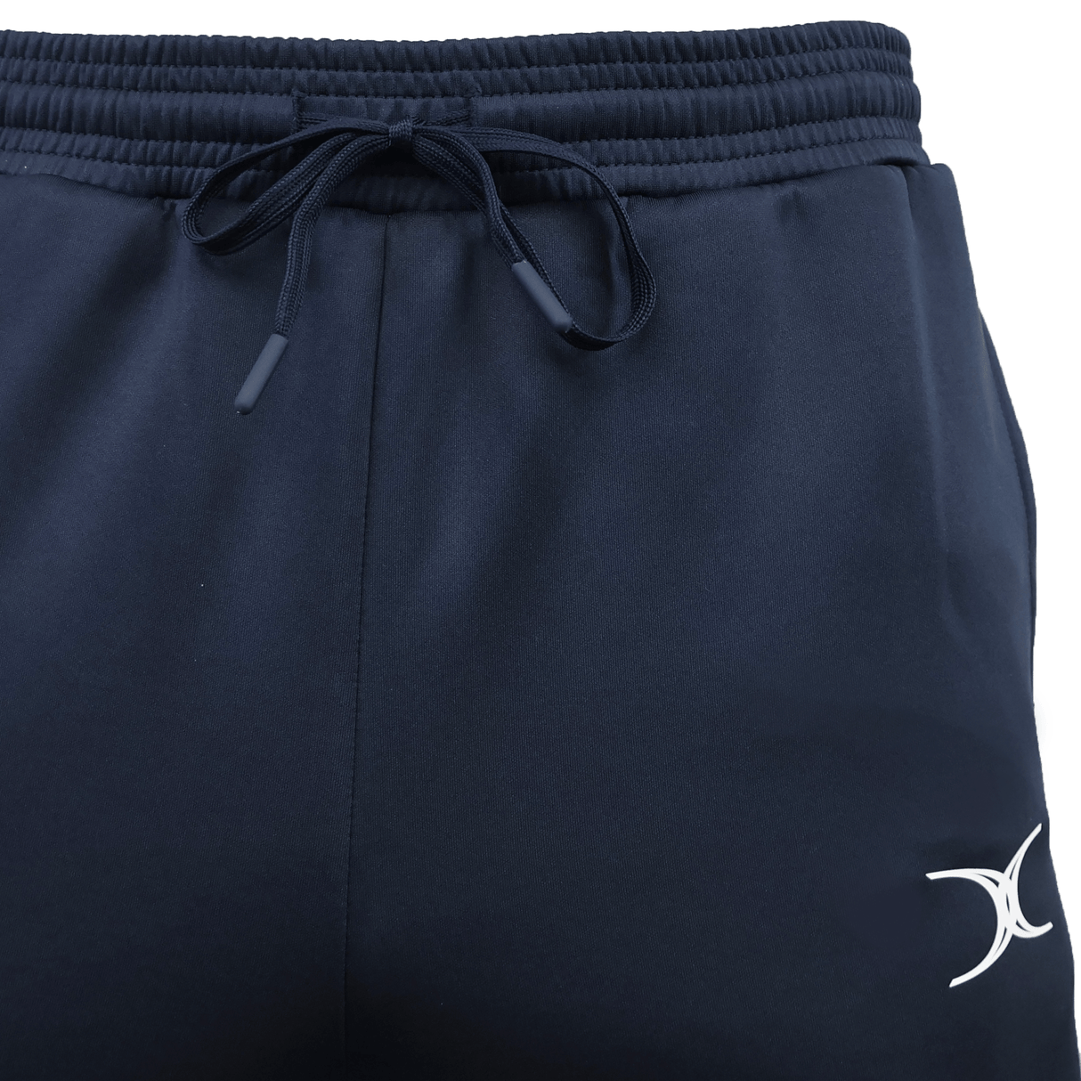 Close-up of navy blue Gilbert GTS Training Pants by Gilbert, featuring an elastic waistband, drawstring, and a white crescent logo on the left leg—ideal for rugby training.