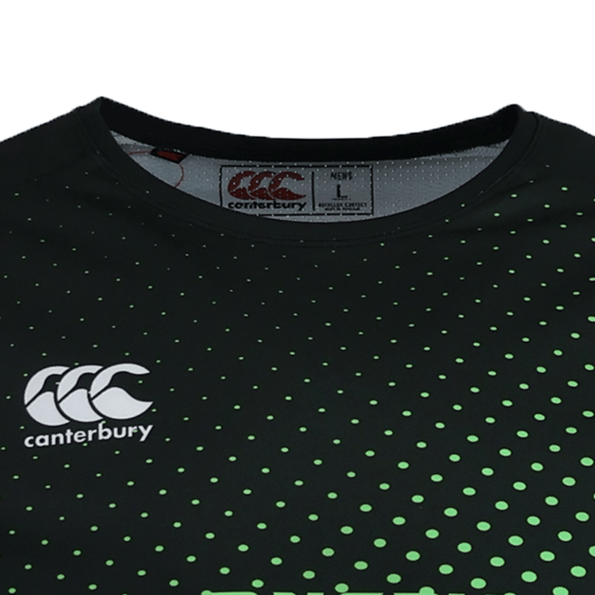 Close-up of the Teamatical CANTERBURY ECO SUBLIMATE SS RAGLAN TEE - MENS in black with a green dotted pattern, moisture-wicking fabric, and "Large" size label and logo visible inside the collar.