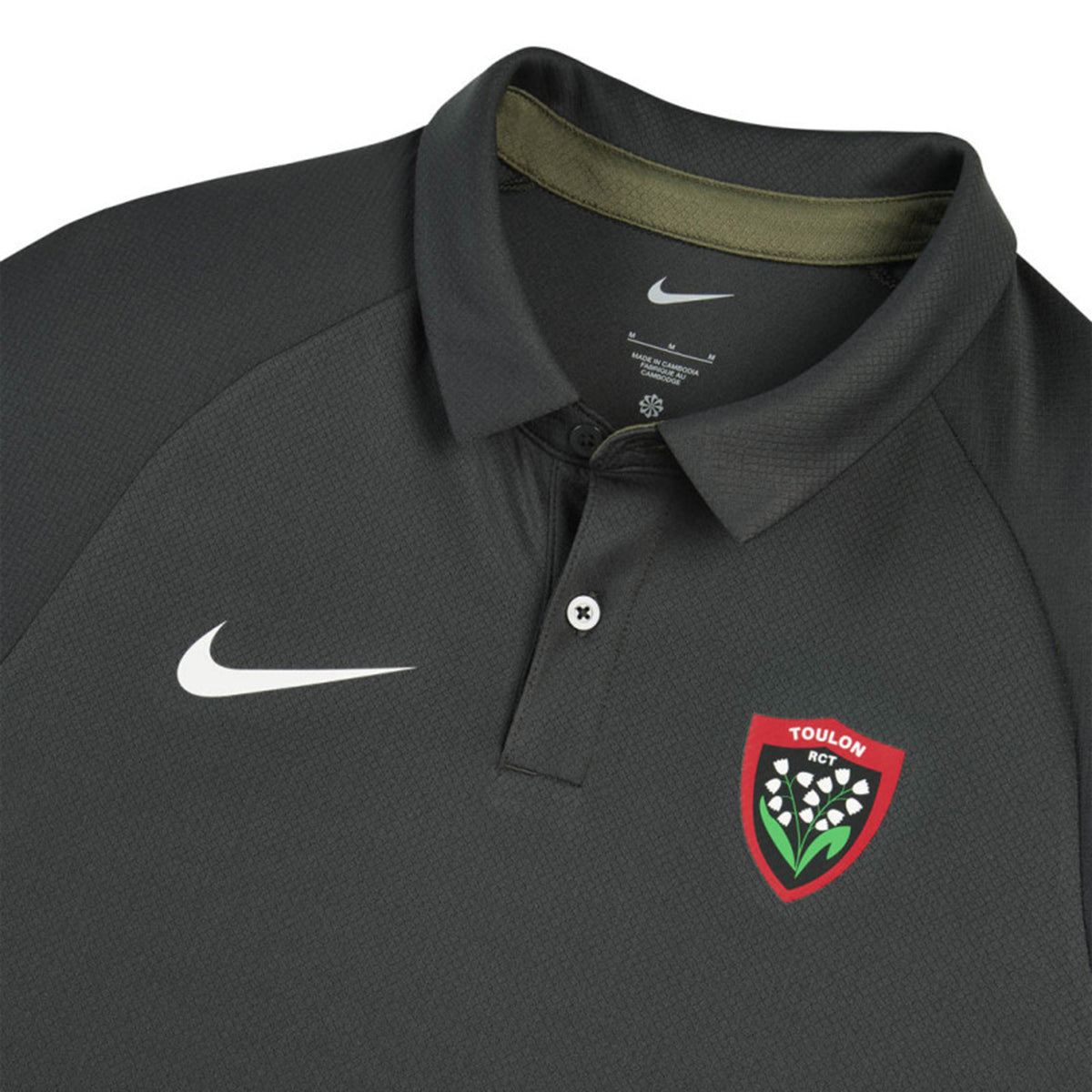 Dark gray short-sleeved RC Toulon Training Polo by Nike with a white swoosh on the chest and a red shield-shaped team crest featuring white lily-of-the-valley flowers.