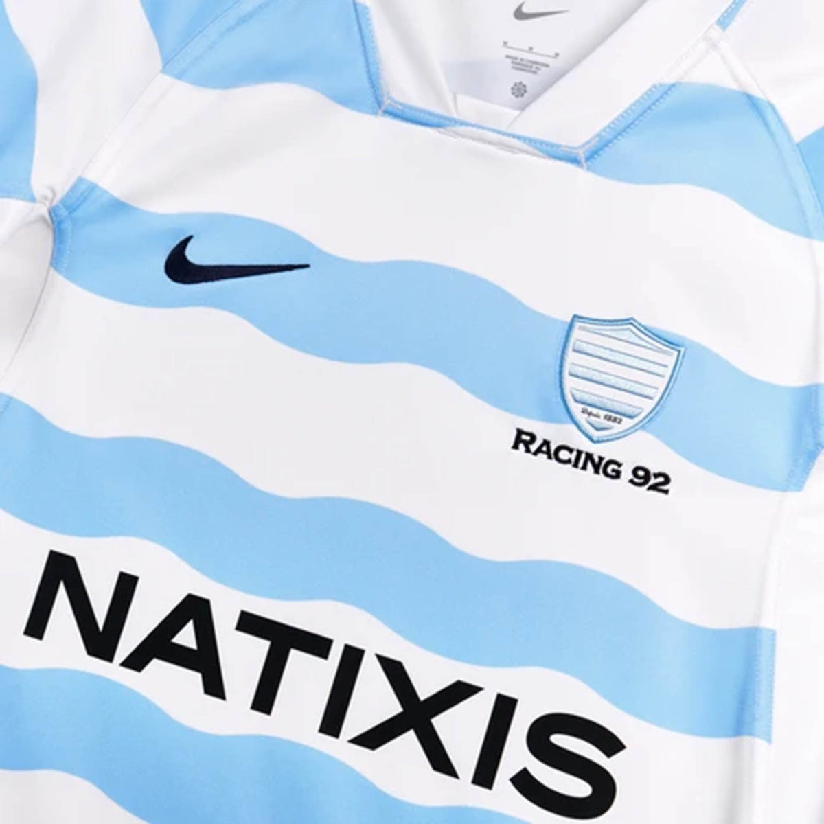 Racing 92 26/27 Stadium Home Jersey by Nike featuring white and light blue stripes, a team crest, “RACING 92” text, and a large “NATIXIS” sponsor logo on the front.
