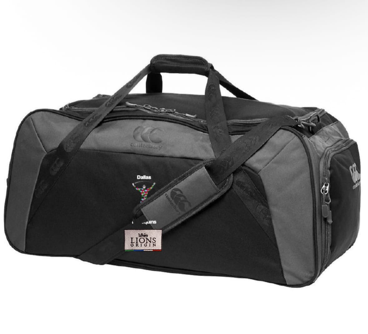 The Dallas Harlequins Lions Origin Holdall Duffle Bag by EMB Canterbury features black and gray colors, two handles, an adjustable padded shoulder strap, multiple zippered compartments, water-repellent fabric, and logos on the front and sides.